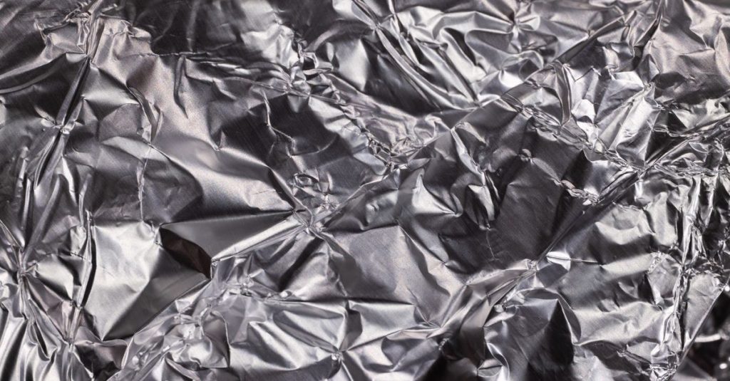 Close-up of shiny crumpled aluminum foil showcasing metallic wrinkled texture.