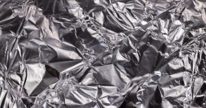 Close-up of shiny crumpled aluminum foil showcasing metallic wrinkled texture.