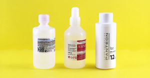 Three bottles with labels on a vibrant yellow surface emphasizing chemical substances.