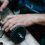 Detailed view of a technician working on a mechanical gear part with precision tools on a workbench.