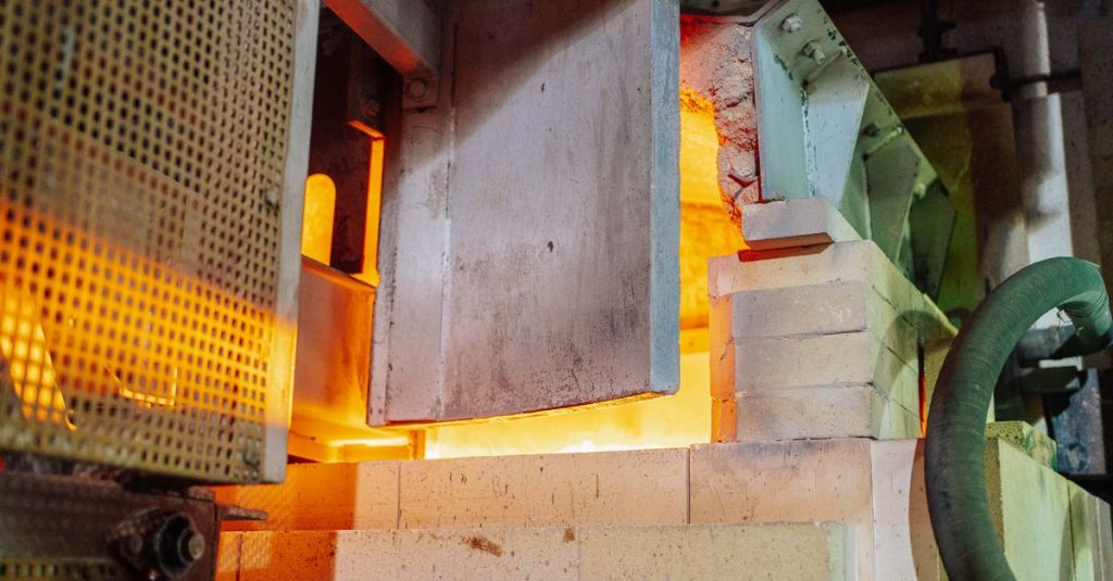 Close-up view of a working glass furnace in an industrial setting, showcasing high-temperature operations.