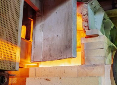 Close-up view of a working glass furnace in an industrial setting, showcasing high-temperature operations.